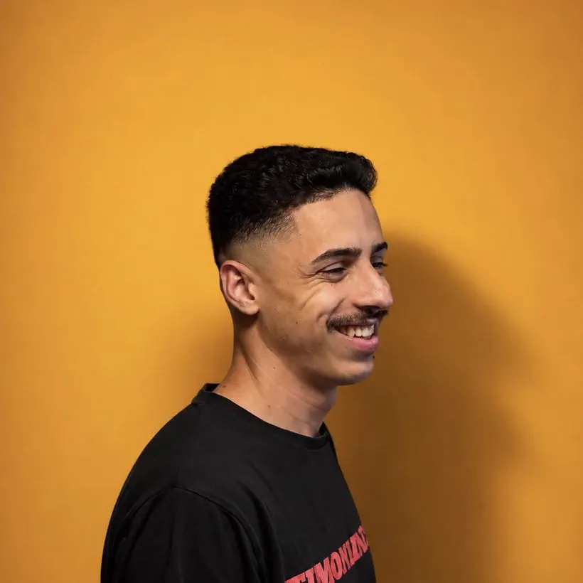 Cliente sorrindo com degradê feito na Barbearia 08
